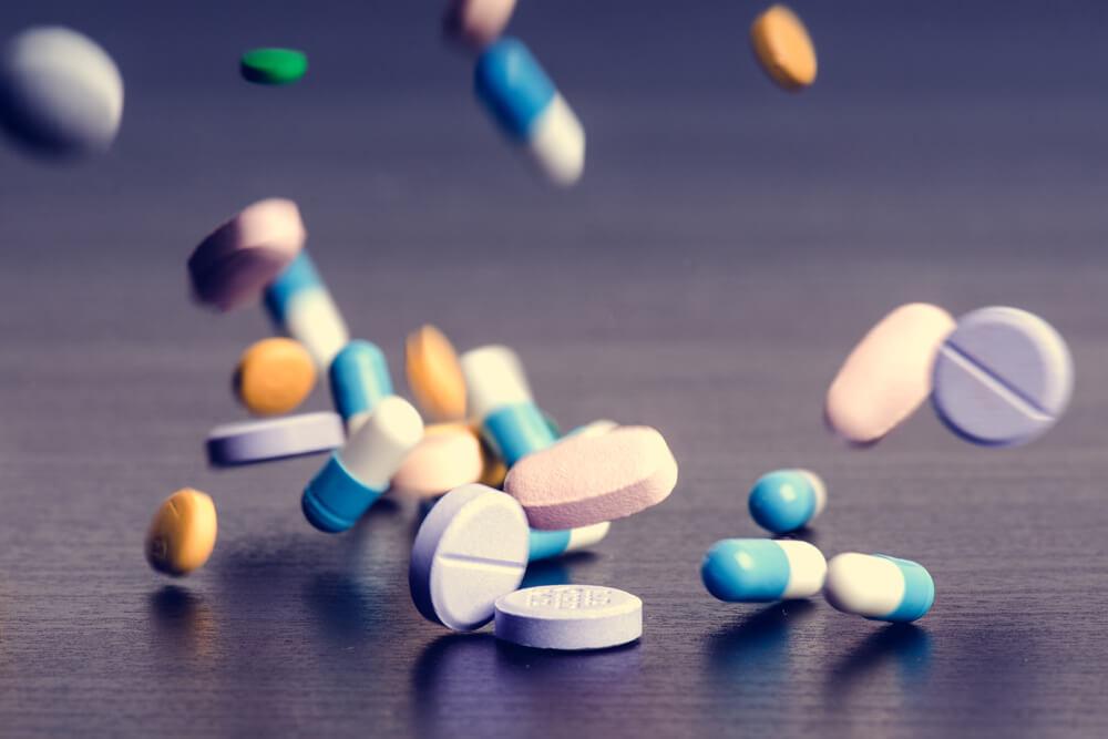Medical pills falling on table top